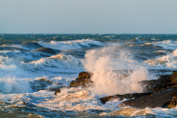 Big waves crash against coastal cliffs. Sea storm