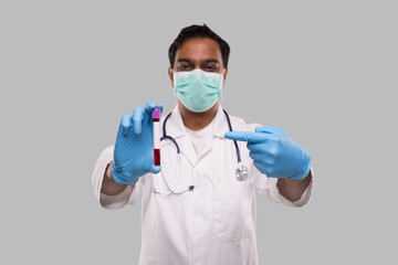 Indian Man Doctor Pointing at Blood Tube Analysis Wearing Medical Mask And Gloves. Science, Medical Concept. Isolated.