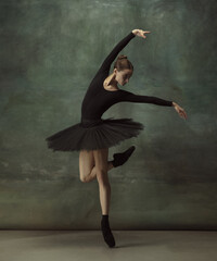 Dancing night. Graceful classic ballerina dancing, posing isolated on dark studio background....