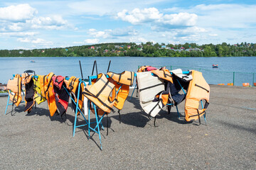 Life jackets on the shore of a picturesque vacation spot. Safe water rides. Summer holiday.