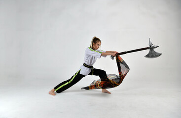 Fototapeta premium beautiful girl fighter in a white and black kimono with fighting swords