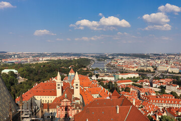 Fototapeta na wymiar view on the roofs of Prague, the capital of Czech Republic with cloudy blue sky and great view on the Moldova in the center of this picture