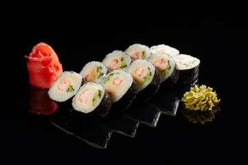 Japanese Cuisine - Appetizing Salmon Sushi Set. Philadelphia Sushi Roll - Maki Sushi with Philadelphia Cheese inside on mirror black background. Smoked salmon rolls served on a plate
