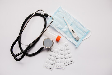 stethoscope pills and mask on white background