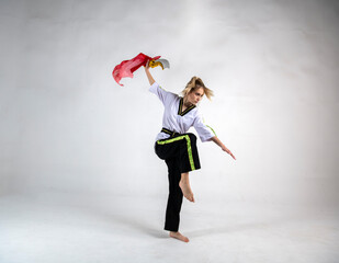 beautiful girl in a white and black suit does exercises with golden battle swords