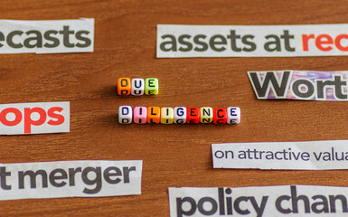 DUE DILIGENCE spelt using colorful letter beads with common business-related title from newspaper cuts. Selective focus on beads only.