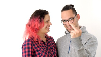Man and a woman hug, laugh and play the fool. Modern hipster family. Wife with pink hair and...