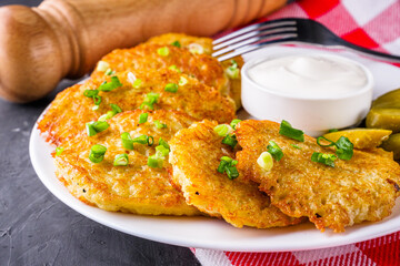 Delicious crispy potato pancakes on dark stone background