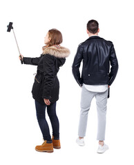 Back view of couple in winter jacket photographed on a mobile phone in winter jacket.