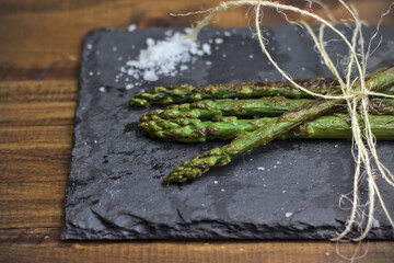 Espárragos verdes o trigueros a la plancha sobre una pizarra con sal gorda