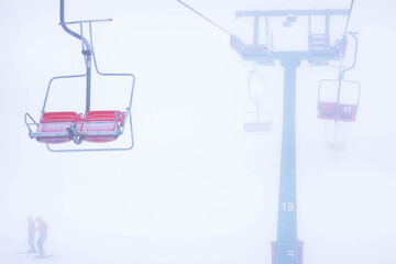Fototapeta na wymiar Chairlift in the mountains, winter view of the spores, rest in the mountains, skiing, red seats