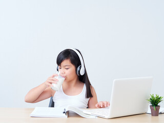 Schoolgirl drinking milk at home.