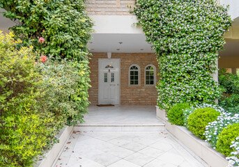 elegant family house entrance marble covered pathway between the garden to white door