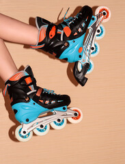 Roller skates on the child's feet on a beige background.