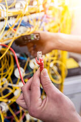 Network engineer working in server room. Connecting network cables to switches