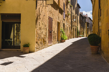Sunny streets with colorful flowers with contrasting shades. Walk the Tuscan town