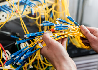 Network engineer working in server room. Connecting network cables to switches