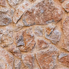 rough brown stone wall close up, seamless textured background