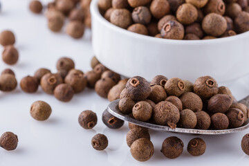 fresh spicy peppers allspice on white acrylic background