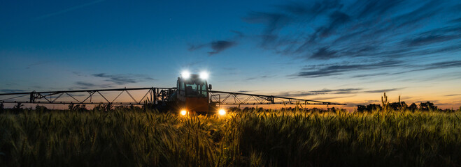 Machine for spraying pesticides and herbicides on a field at night.