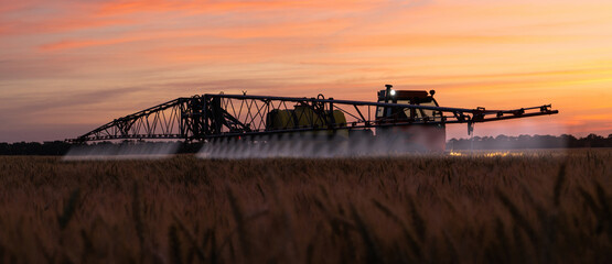Machine for spraying pesticides and herbicides on a field at night. © scharfsinn86