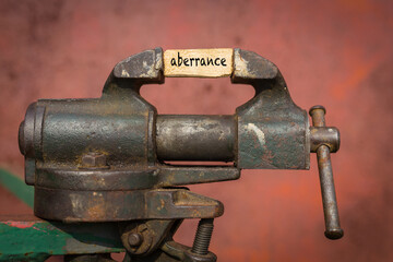 Vice grip tool squeezing a plank with the word aberrance