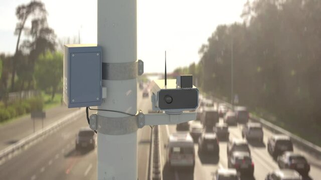 Traffic surveillance camera above highway, monitoring violations, traffic jam