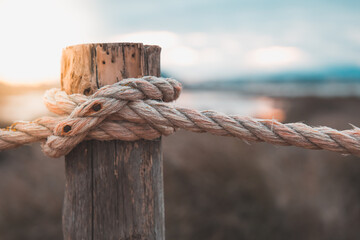 Rope on a pole of Molentargius park at sunset, lens blur and bokeh background