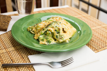 wholesome breakfast. omelet with broccoli on green plate
