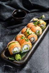 Sushi roll Philadelphia with salmon, avocado, cream cheese. Sushi menu. Japanese food. Black background. Top view