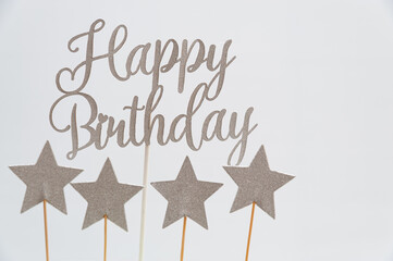 Happy Birthday written in silver letters with star shapes. Isolated on white background. Copy space.