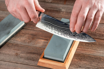 Man sharpening a chef's knife with a wet stone