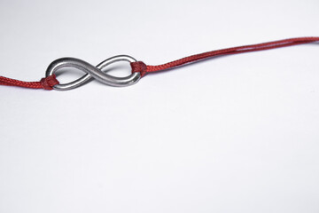 red ribbon bracelet with an infinity sign. jewelry and accessories concept. Isolated, copy space. Macro Shot. High quality photo