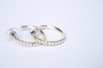 Round gold earrings with white stones. jewelry and accessories concept. Isolated, copy space. Macro Shot. High quality photo