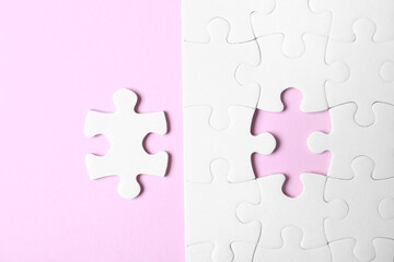 White puzzle with separated piece on pink background, flat lay