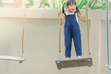 Close-up background view Of cute girls, sitting on the swing and swinging with force, learning between ages or physical exercise for good health