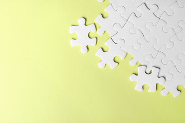 Blank white puzzle pieces on yellow background, flat lay. Space for text
