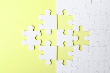 Blank white puzzle with separated pieces on yellow background, flat lay