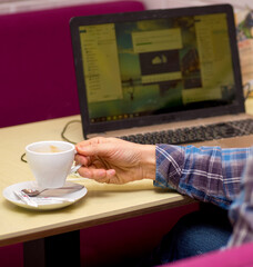 remote work, man sits at a computer, works remotely and drinks coffee