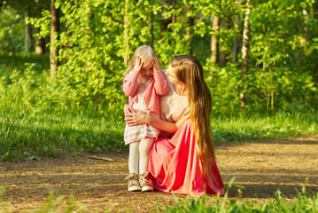 Obraz na płótnie Canvas mom asks her little daughter what happened during a walk in the park