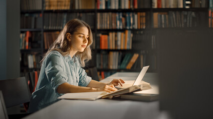 University Library: Smart Caucasian Girl uses Laptop, Writes Notes for Paper, Essay, Study for...