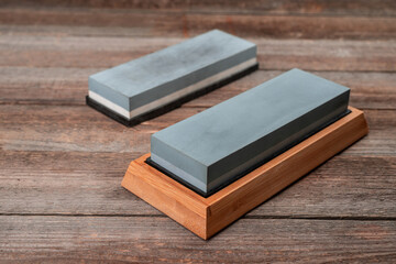Close-up on two whetstones on a rustic wooden table