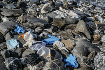 Medical waste,Virus mask and plastic gloves garbage discarded on rocky sea coast,coronavirus covid19 pollution 