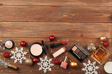 Beautiful composition with Christmas decor and makeup cosmetics on a colored background top view.
