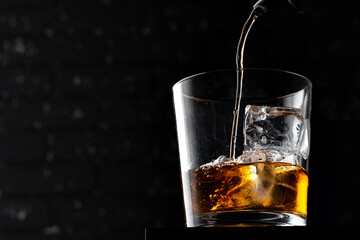Whisky glass against dark black grunge wall