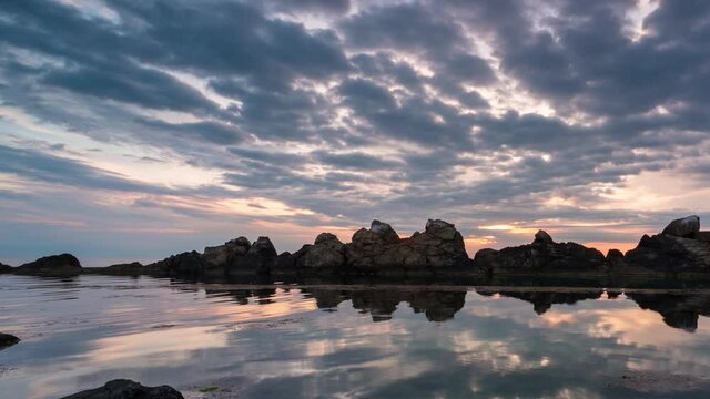 Time lapse with colorful sunrise sky at rocky coastline and calm summer sea, the Black Sea coast, Bulgaria