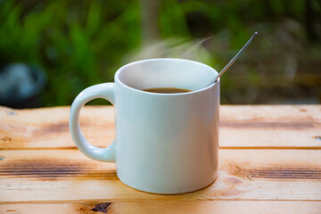 Coffee with steam place on wooden table