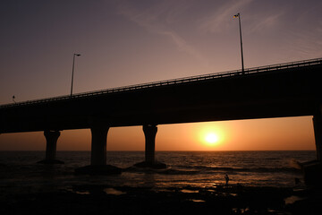 An evening by the beach: Bandra Worli Sea Link, Mumbai during Sunset, Silhouette of the bridge with Sun setting down