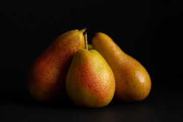 Three pears over a black background