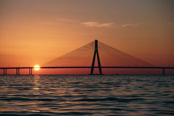 An evening by the beach: Bandra Worli Sea Link, Mumbai View during Sunset, Silhouette of the bridge with Sun going down